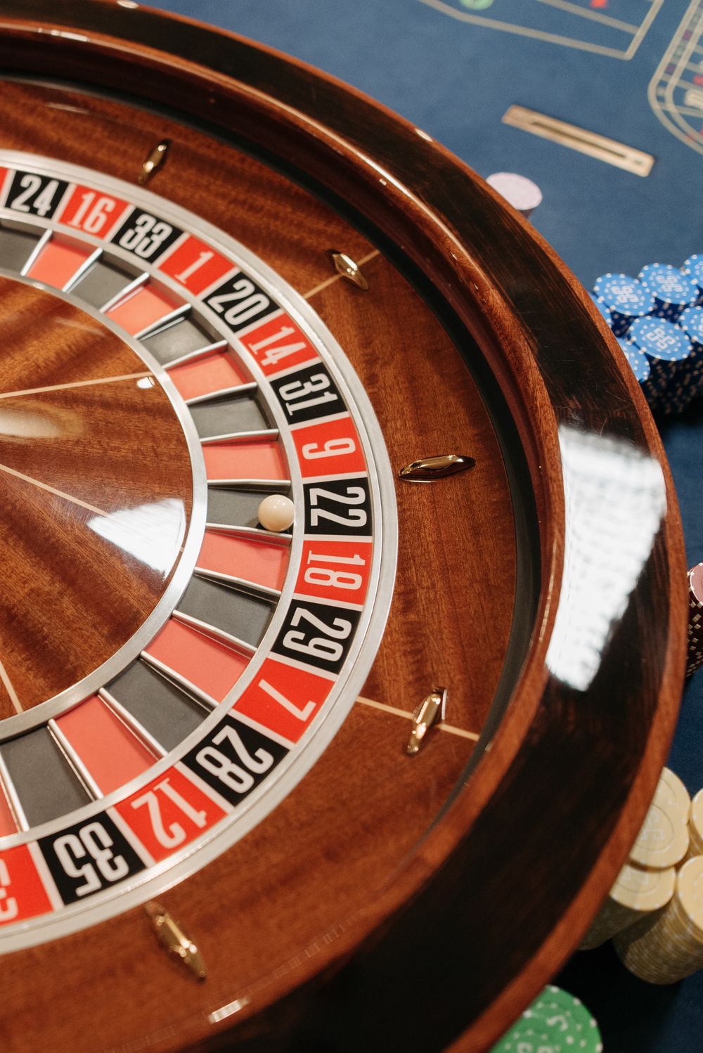 Roda roulette dengan chip kasino di atas meja