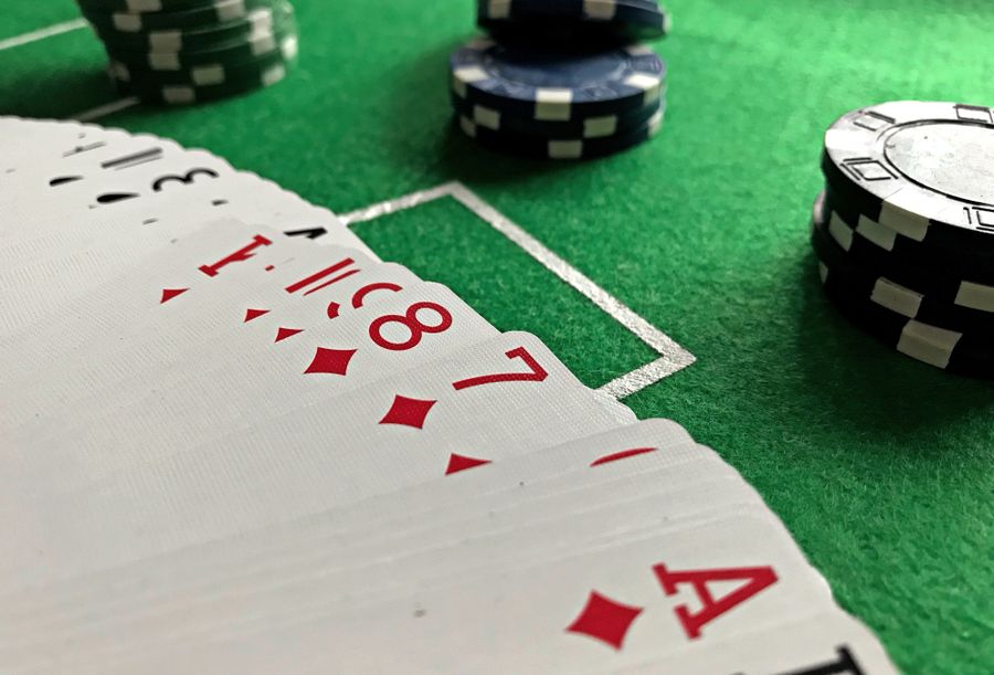 Kartu dan chip poker di atas meja hijau